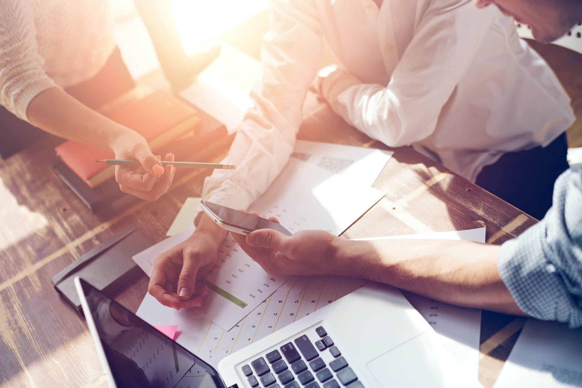 A group of people sitting around a table with papers.